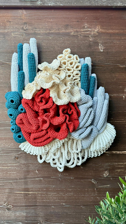 Colorful knitted, crocheted, macrame coral-like sculpture on a wooden surface