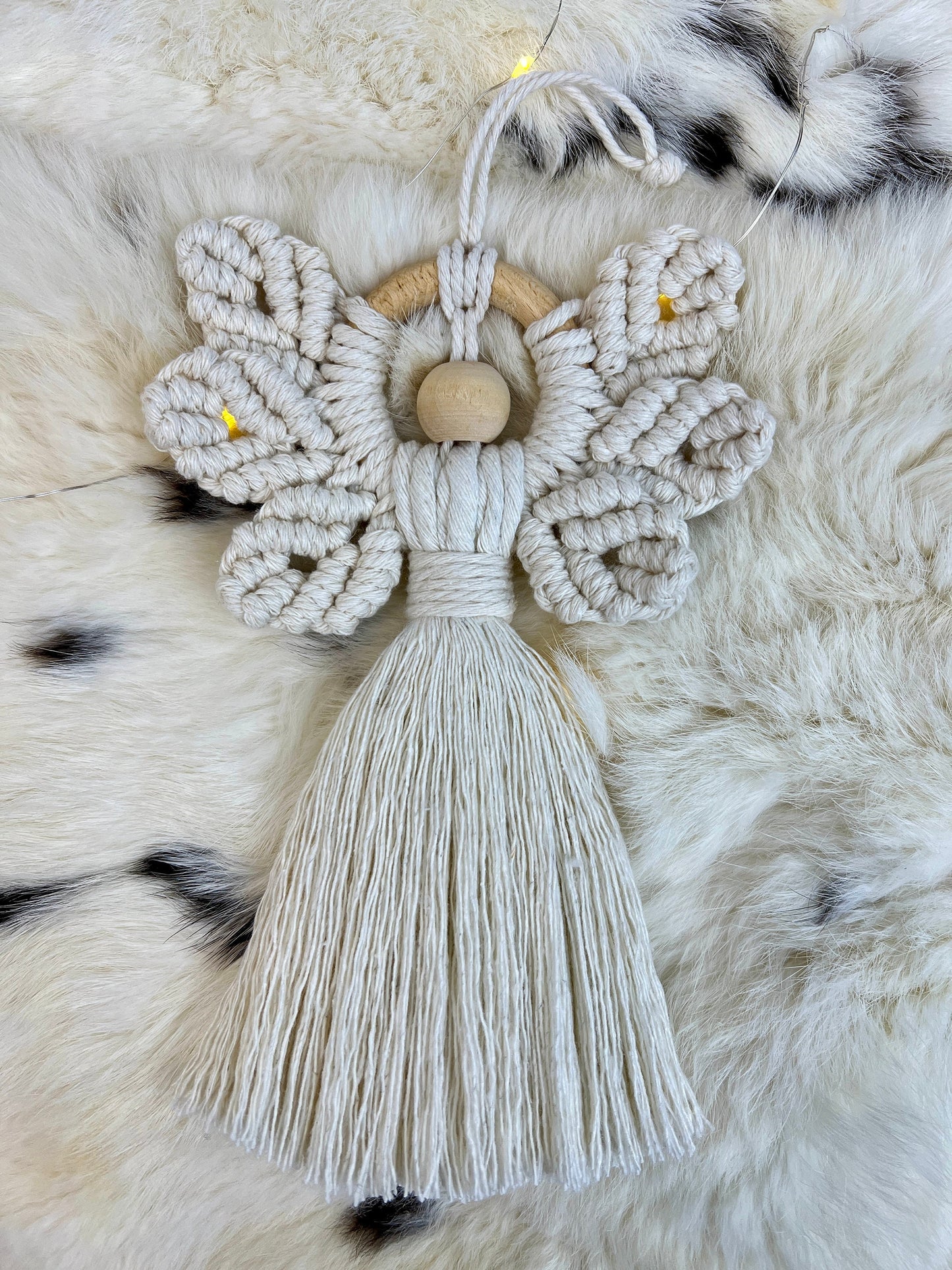 Macrame angel ornament with tassel on a fur surface