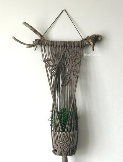 Macrame wall hanging with plant holder on a white background