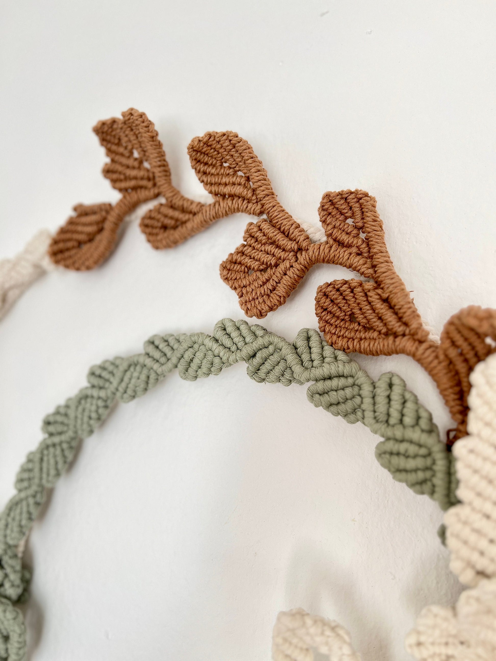 Decorative wreath with knotted yarn design on a white background