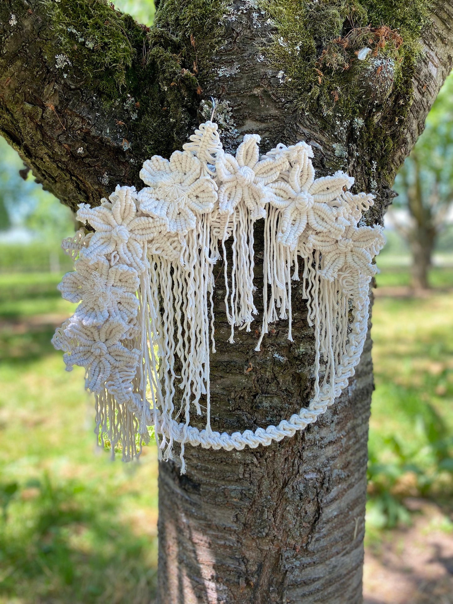 Decorative white lace garment hanging on a tree branch outdoors