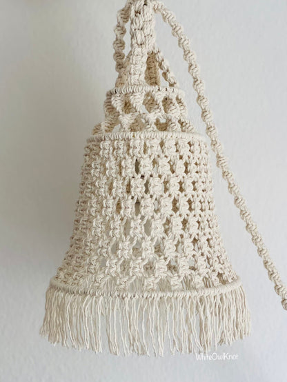 Macrame lampshade with fringes on a plain background