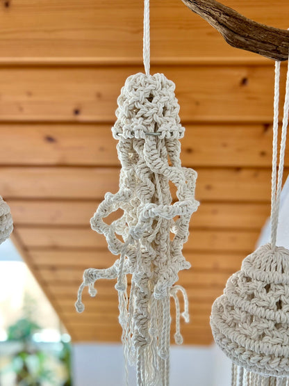 Macrame jellyfish hanging from a wooden ceiling
