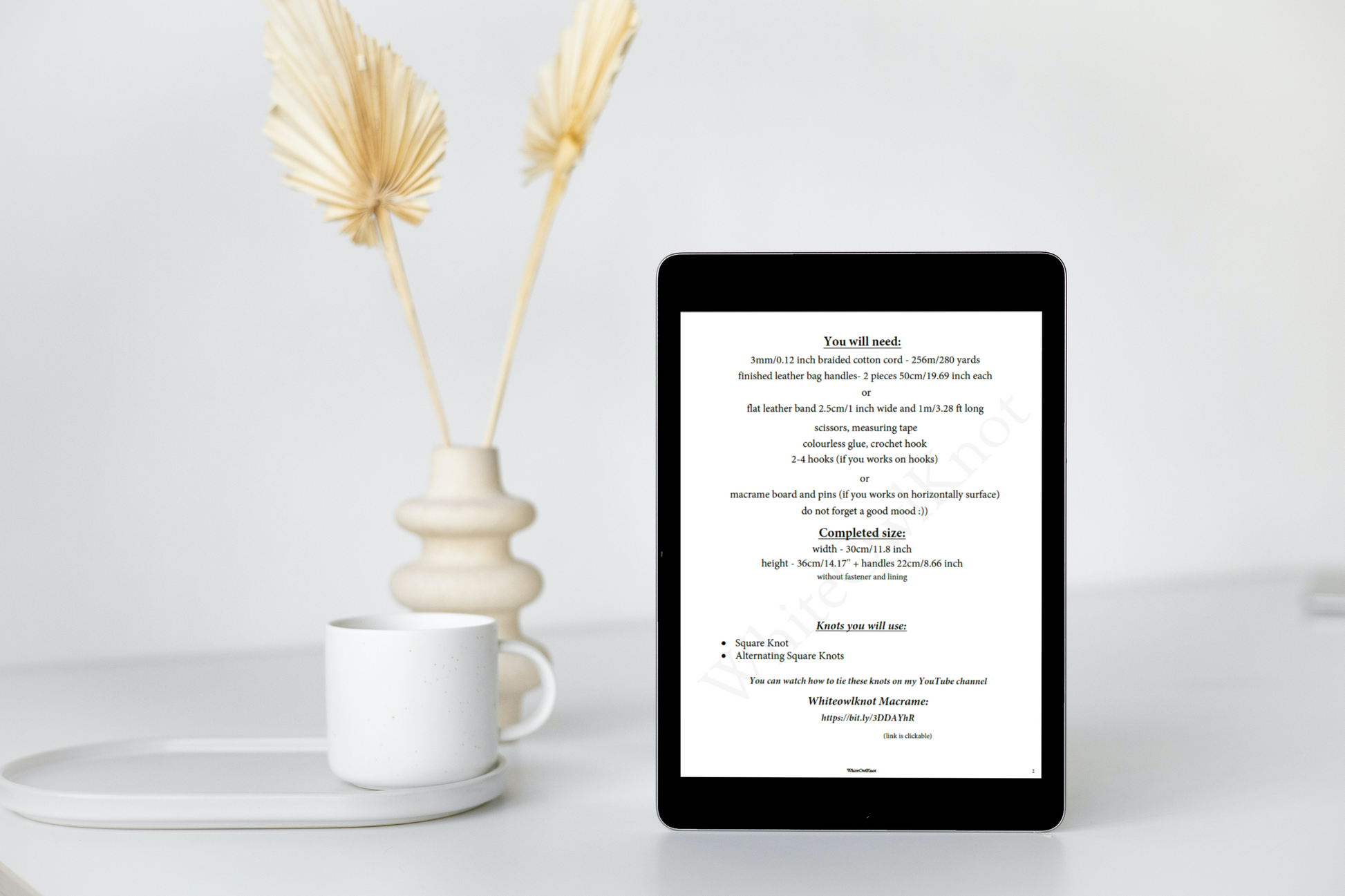 Tablet displaying text on a white surface with decorative elements