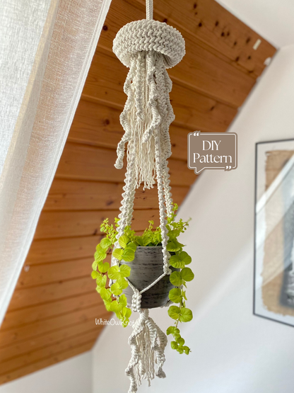 Macrame plant hanger with a plant against a wooden ceiling and white wall.