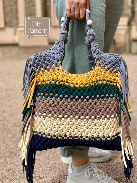 Colorful macrame handbag with fringe held by a person outdoors.