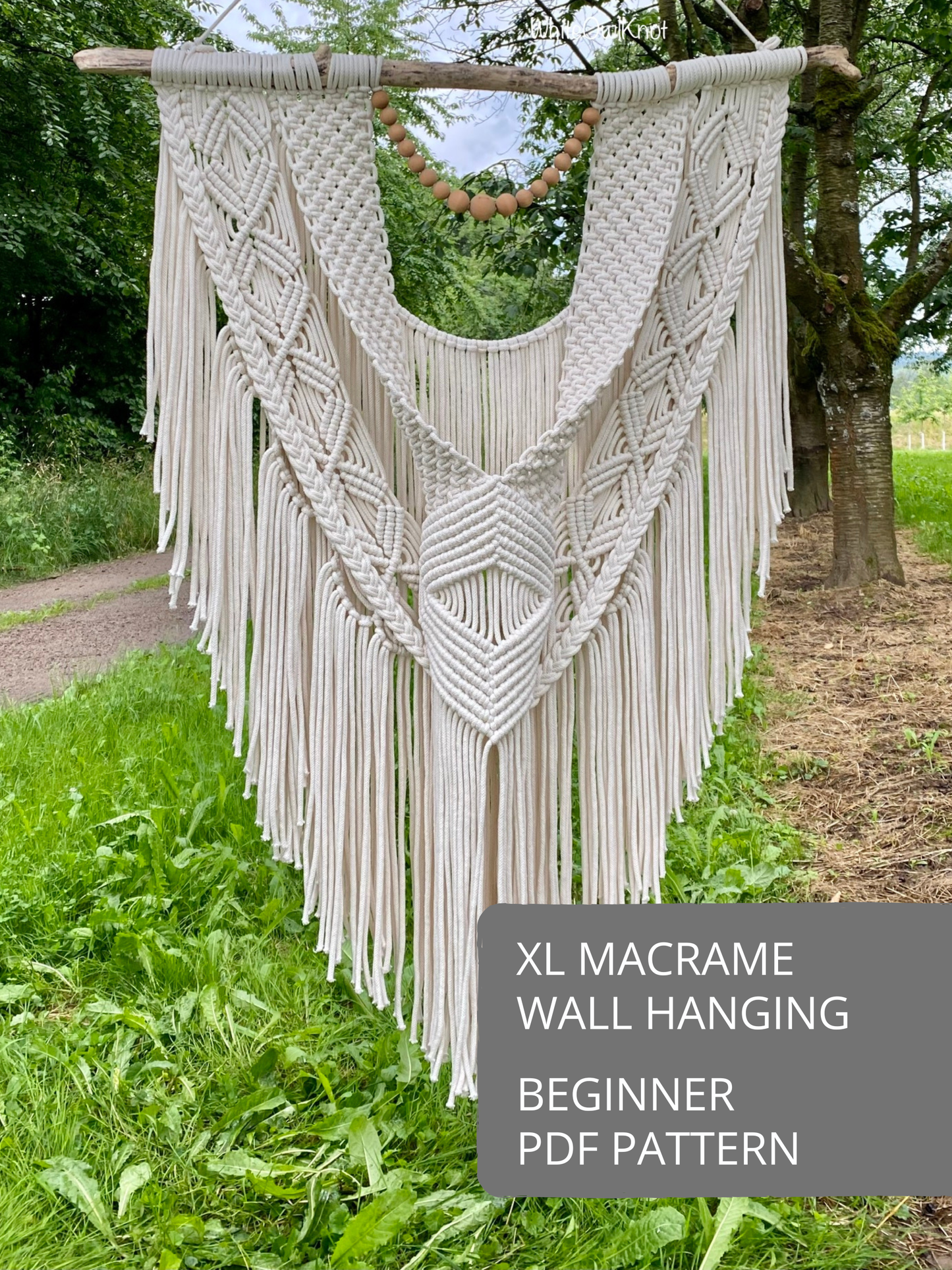 XL macrame wall hanging pattern with symmetrical woven design, detailed knotting, and long fringe, displayed as a finished macramé piece.