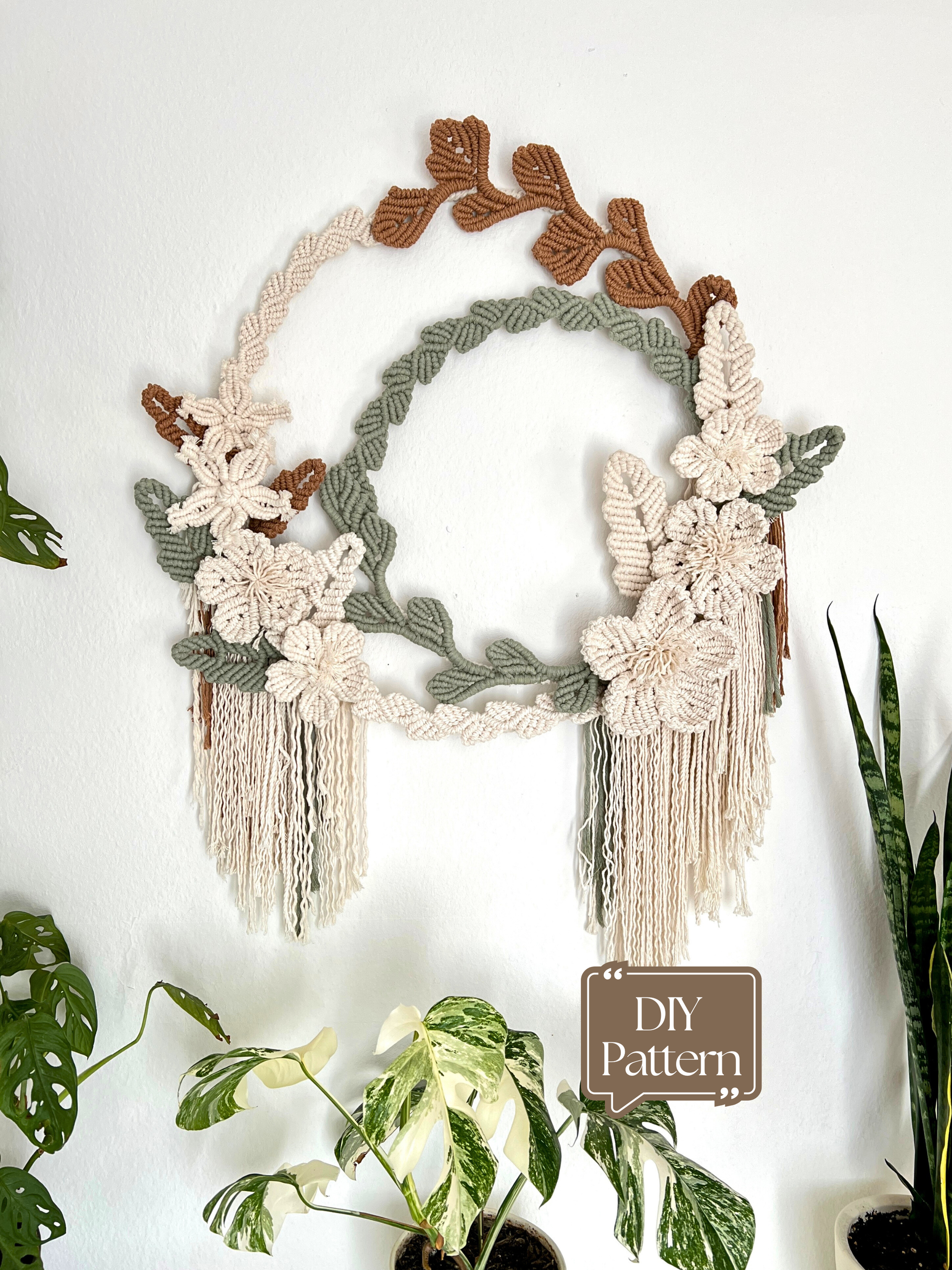 Macrame wall hanging with floral and leaf patterns on a white background
