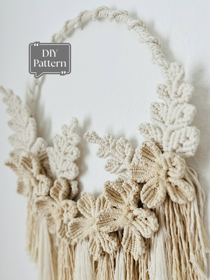 Macrame floral wreath design made with cotton cord, featuring handmade flowers and leaves arranged on circular hoops for wall décor.