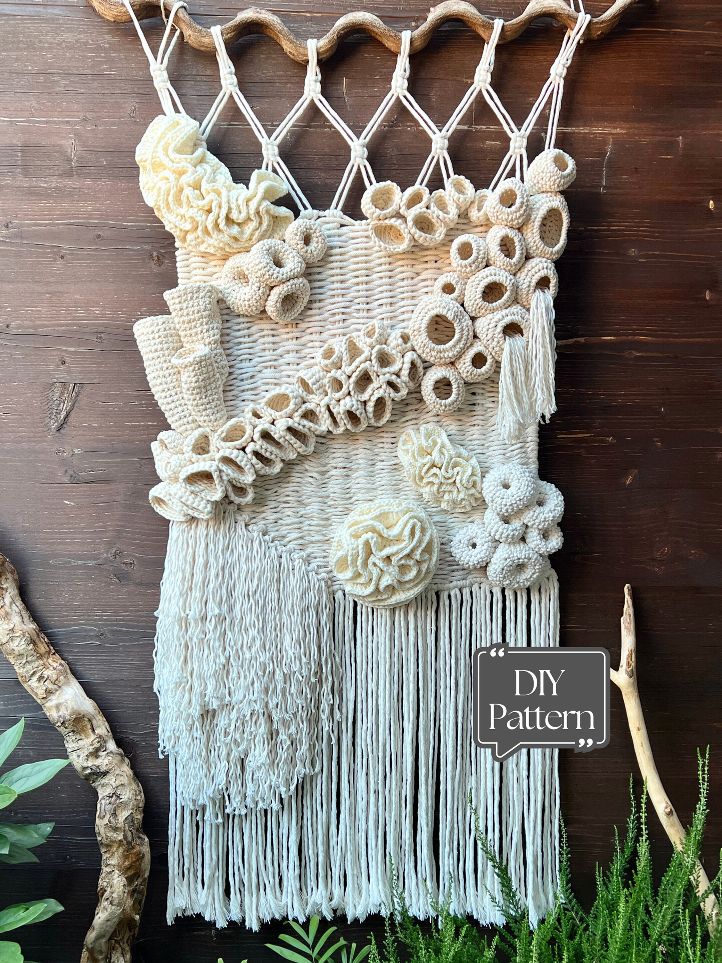 Macrame wall hanging with coral reef patterns and fringe on a wooden background