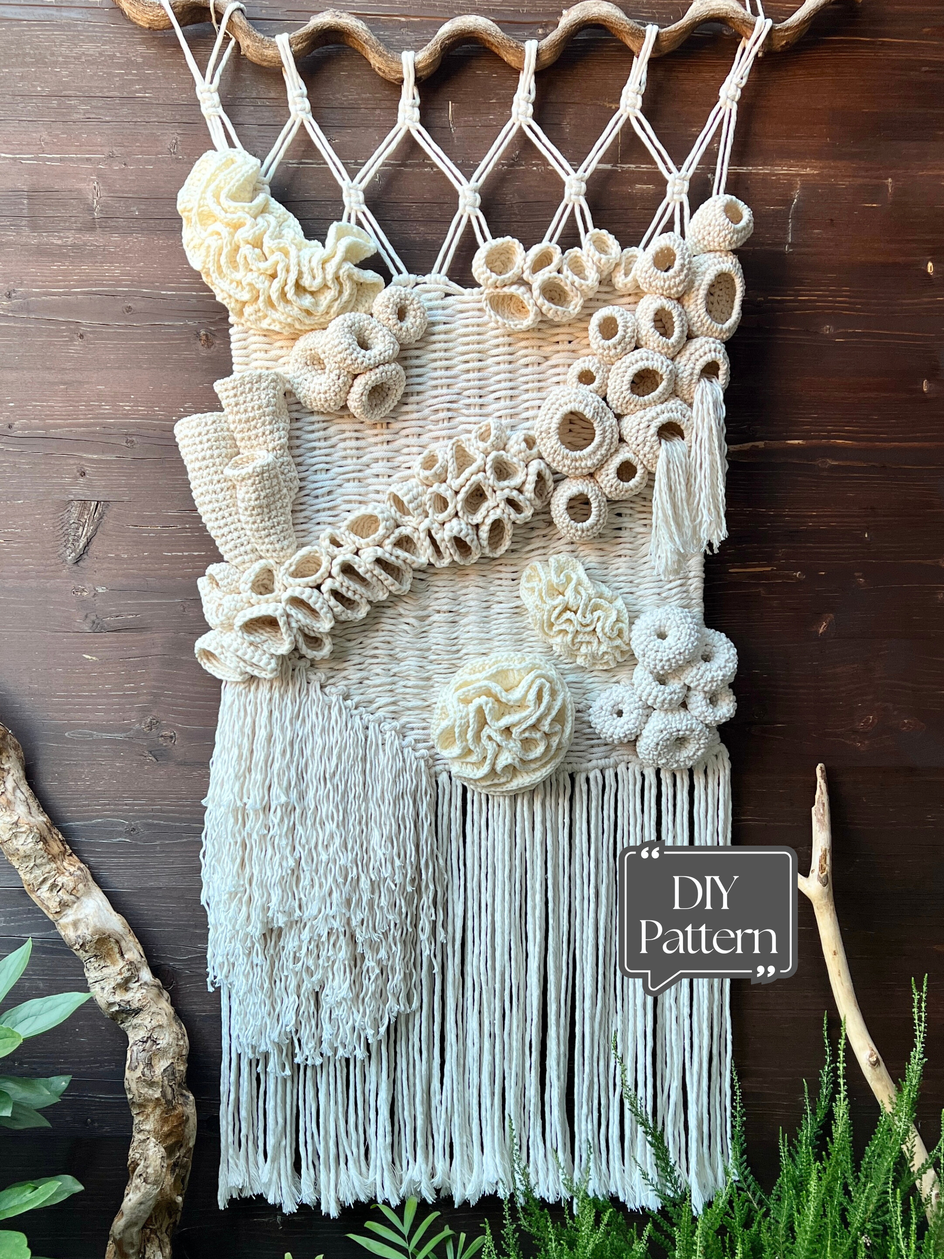 Macrame wall hanging with coral reef patterns and fringe on a wooden background