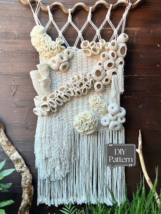 Macrame wall hanging with coral reef patterns and fringe on a wooden background