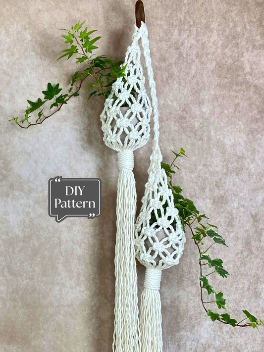 Double macramé plant hanger with two small pots hanging from one wooden ring, featuring open net knotting and long tassels; DIY macramé plant hanger PDF pattern.