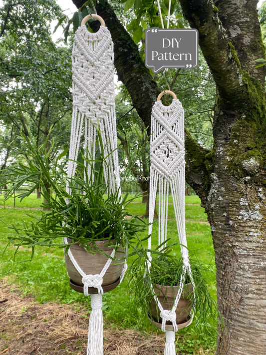 Set of two white macramé plant hangers with decorative knotted designs and tassel details, hanging outdoors on a tree with potted plants; shown as a DIY macramé PDF pattern example.